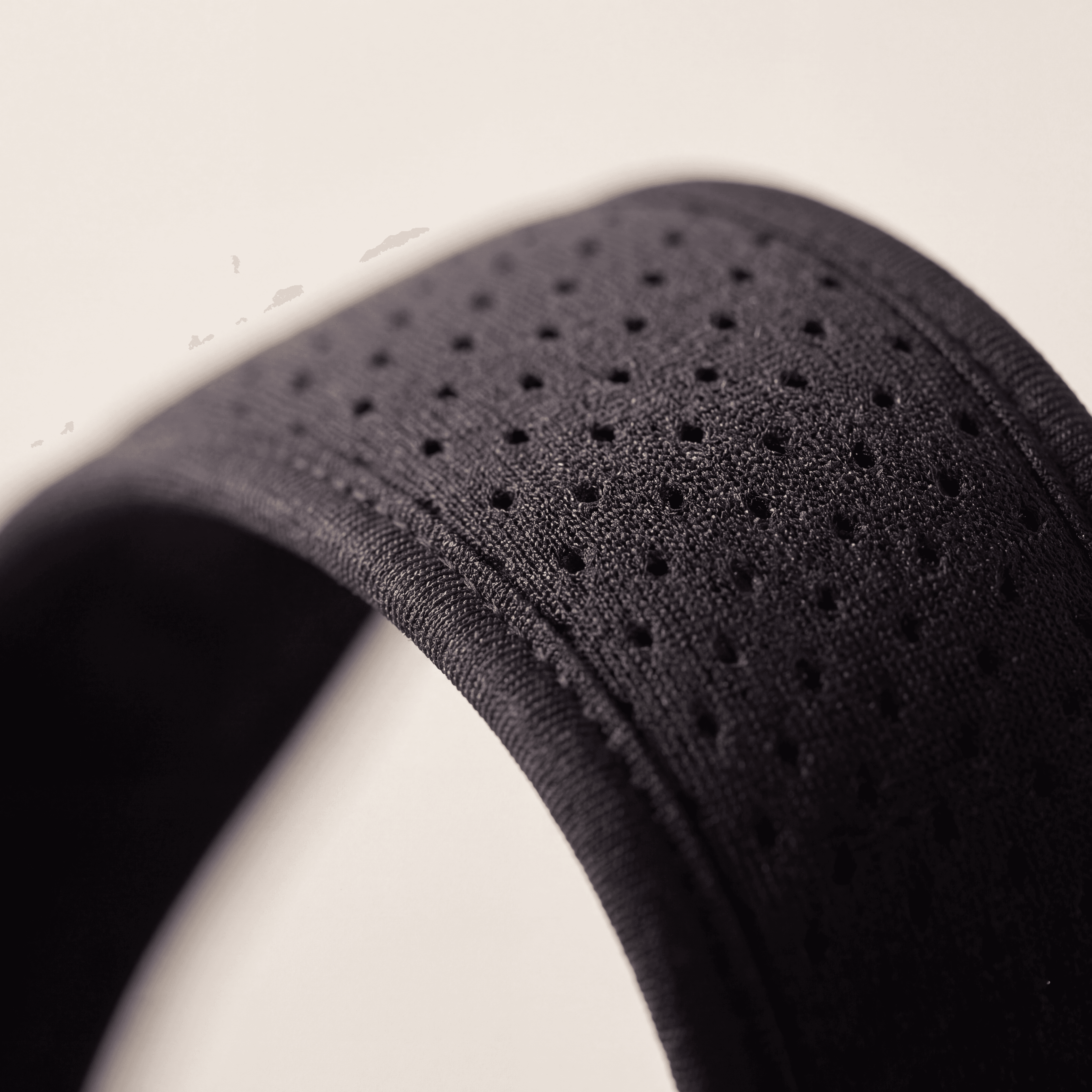Macro detail of the perforated breathable mesh strap of the Aligned Brace.